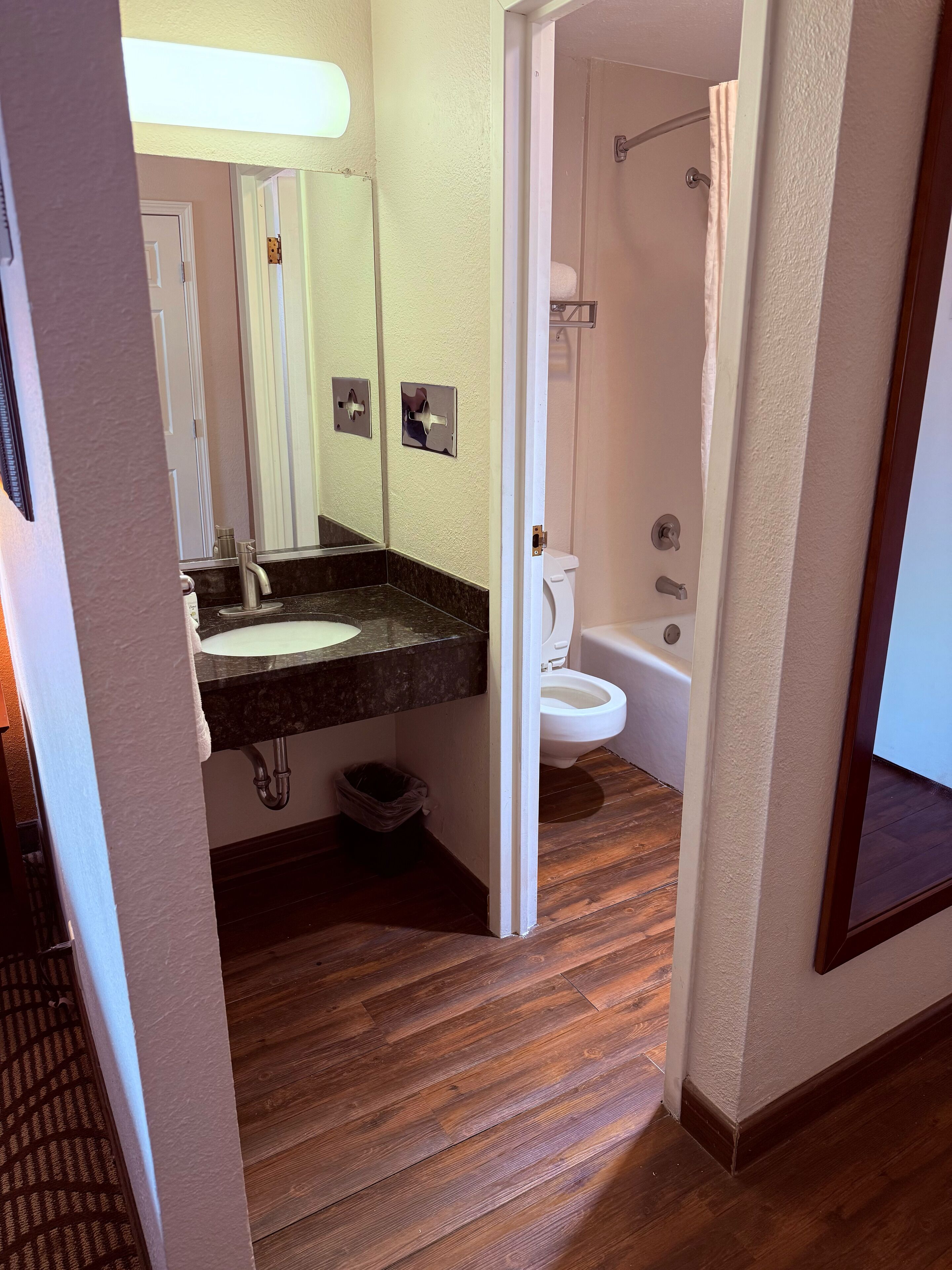 A bathroom with a sink, mirror, toilet, and shower.