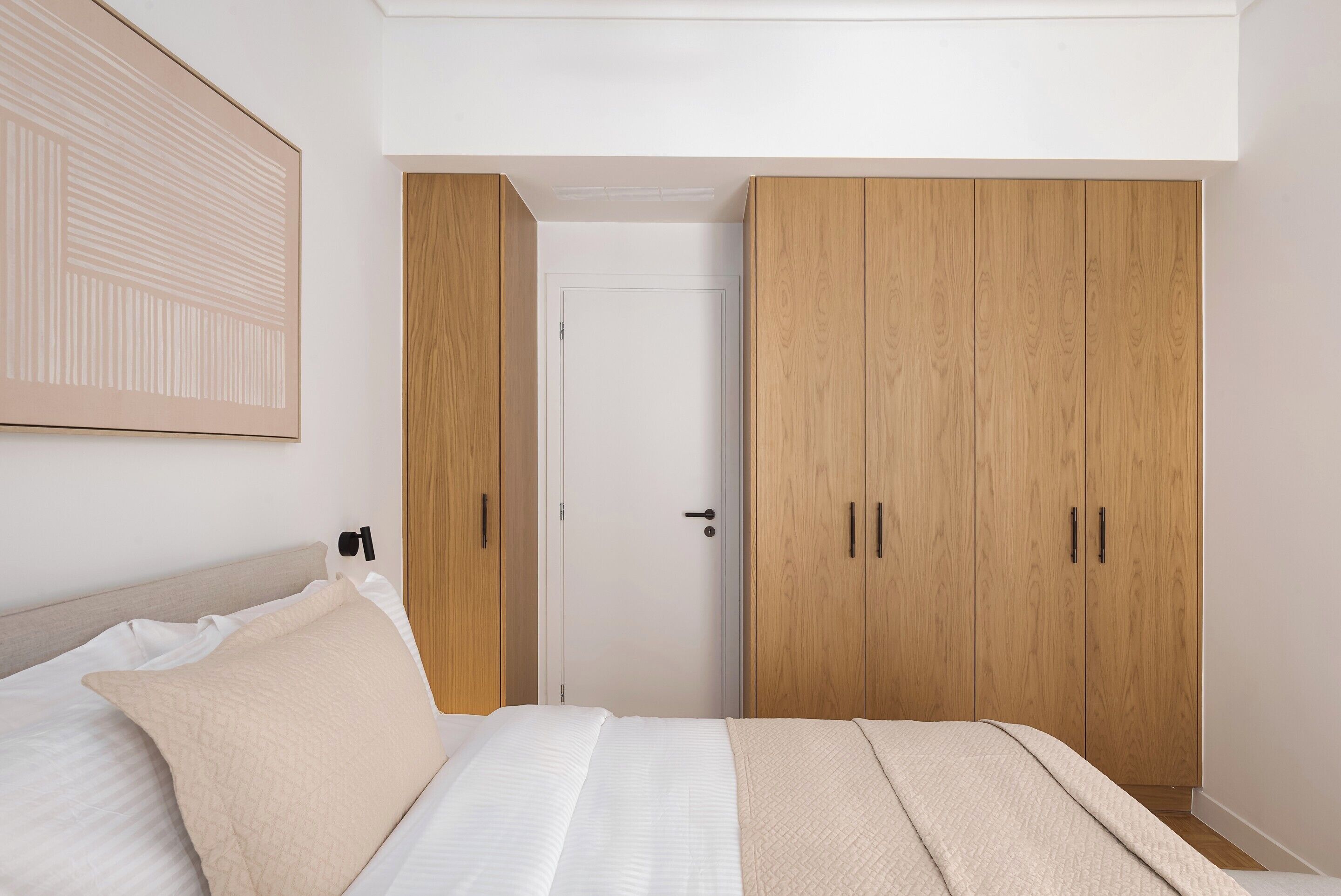 Un dormitorio con cama, armario y puerta.