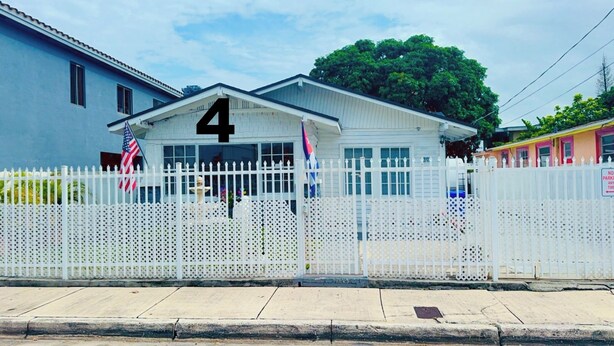 A building with a white picket fence and a number '4' on the front. - Affordable private bedroom with private bath with WiFi, AC in Miami B4 (Miami)