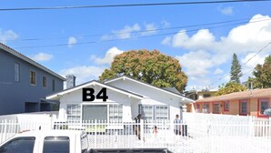 A building with a 'B4' sign, a white picket fence, and a 'NO PARKING ANY TIME' sign. - Affordable private bedroom with private bath with WiFi, AC in Miami B4 (Miami)