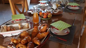 A breakfast buffet with pastries, fruits, and beverages on a wooden table. - Bed and Breakfast 'Nature' with Shared Terrace, Shared Garden and Wi-Fi (Videcosville)