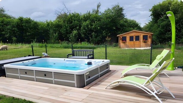 A hot tub on a wooden deck with lounge chairs and a small wooden structure in the background. - Bed and Breakfast 'Nature' with Shared Terrace, Shared Garden and Wi-Fi (Videcosville)