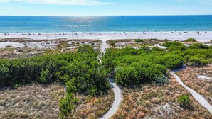 A beach with a clear path leading to the water, surrounded by dense green vegetation. - 3bed on Siesta w/ direct beach access! (Siesta Key)