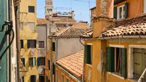 A narrow street with closely packed buildings, a church tower, and a visible church steeple.