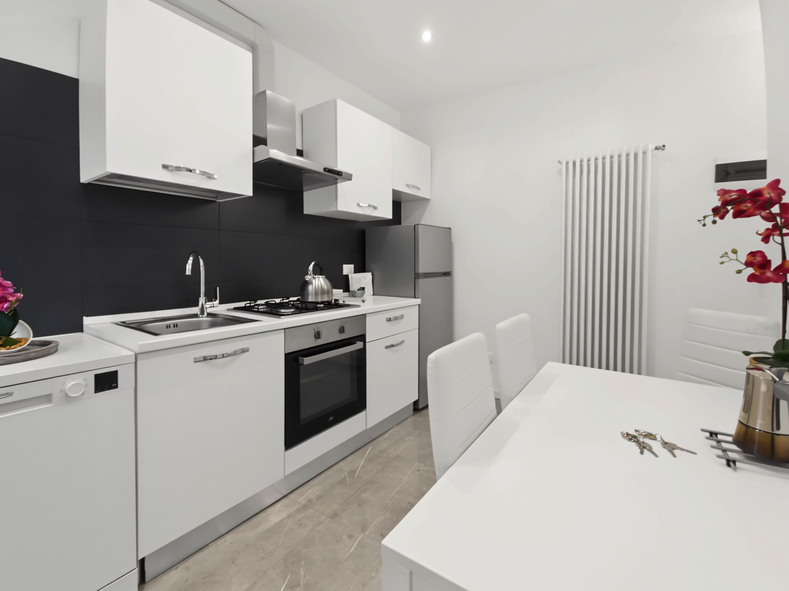 A modern kitchen with white cabinetry, a gas stove, a built-in oven, and a dishwasher.