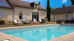 A swimming pool with lounge chairs, a building with a tiled roof, and a clear sky. - Guest Room 'Bleuet Adapted for PRM' with Private Terrace, Shared Garden and Wi-Fi (Gabillou)