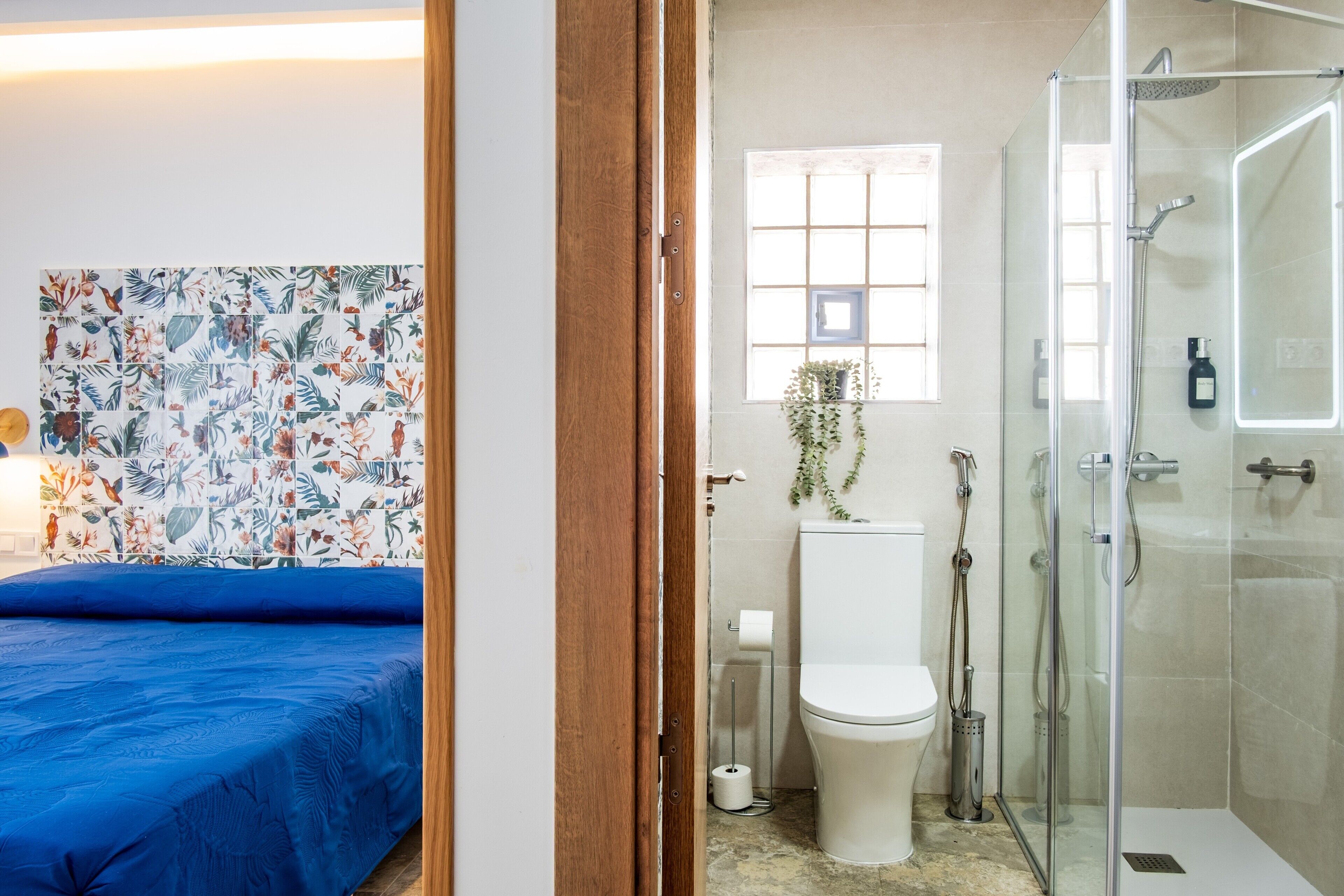 Een badkamer met douche, toilet en raam met uitzicht.