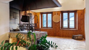 Un intérieur rustique avec des murs en bois, une cheminée en pierre et une grande fenêtre.