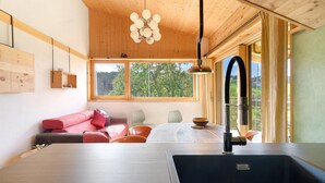 A modern kitchen with a wooden ceiling, a large window, a sink, and a dining area with a table and chairs. - Apartment 'Kesselmoos' with Mountain View, Shared Garden and Wi-Fi (Nova Ponente)