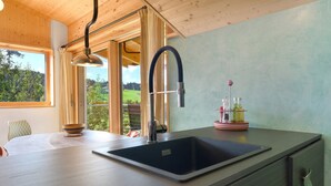 A modern kitchen with a large sink, wooden ceiling, and a view of greenery outside. - Apartment 'Kesselmoos' with Mountain View, Shared Garden and Wi-Fi (Nova Ponente)