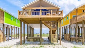 A beachfront property with a wooden deck and a covered area.