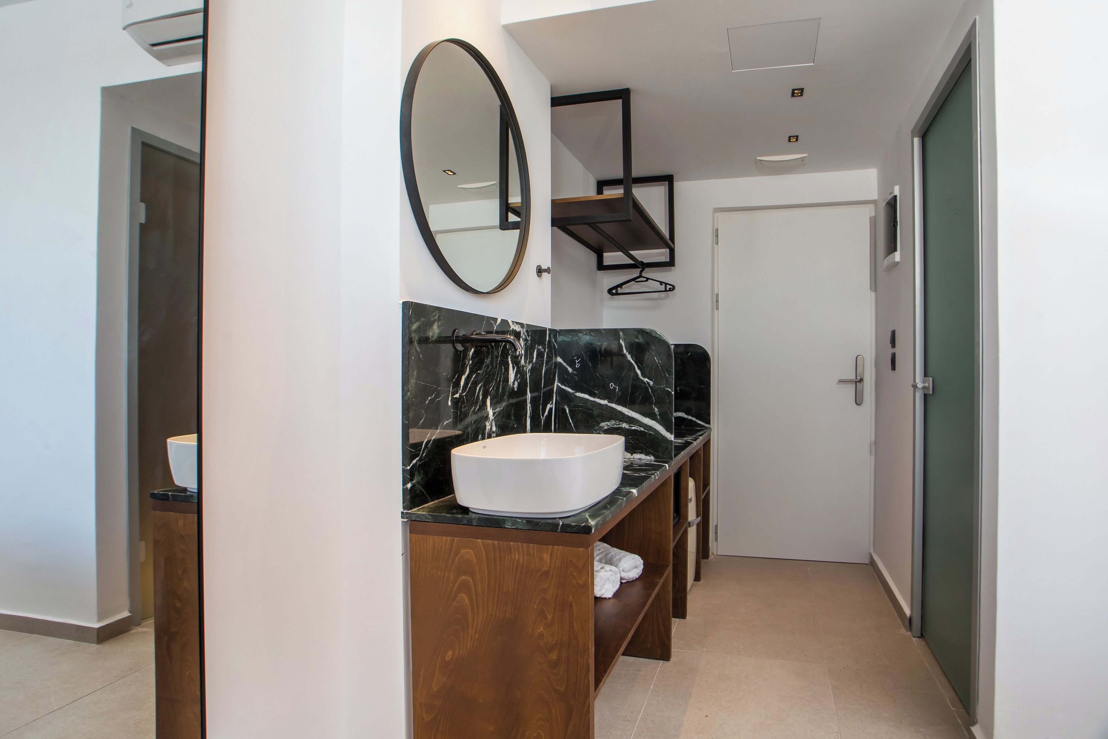 A modern bathroom with a large oval sink, wooden vanity, and a mirror.