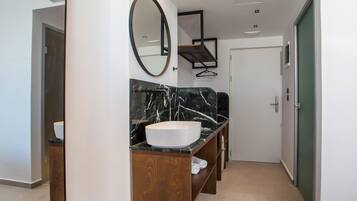 A modern bathroom with a large oval sink, wooden vanity, and a mirror.