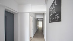 A corridor with a sign indicating rooms 201-204 at the ERMOU 44 CITY HOTEL. - Ermou 44 City Hotel (Faliraki)