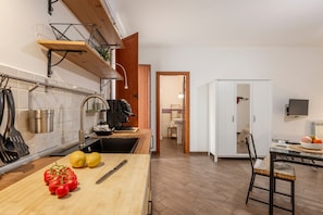 Une cuisine moderne dotée d’un plan de travail en bois, d’un évier et d’un coin repas avec une table et des chaises.