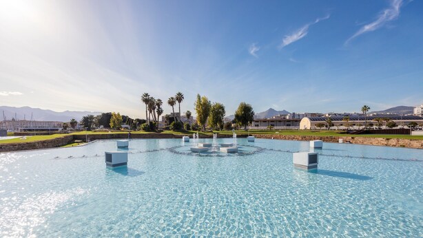 A large outdoor pool with a central fountain, surrounded by palm trees and buildings in the background. - Apartment 'Del Porto, Palermo' with Balcony, Wi-Fi and Air Conditioning (Palermo)
