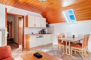 A compact kitchen with white cabinets, a microwave, and a window.