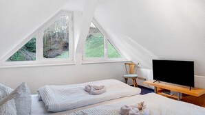 A bedroom with two beds, a TV, and large windows. - Apartment 'Vogelnest' with Mountain View, Shared Pool and Wi-Fi – Not Suitable for Dogs (Wolfach)