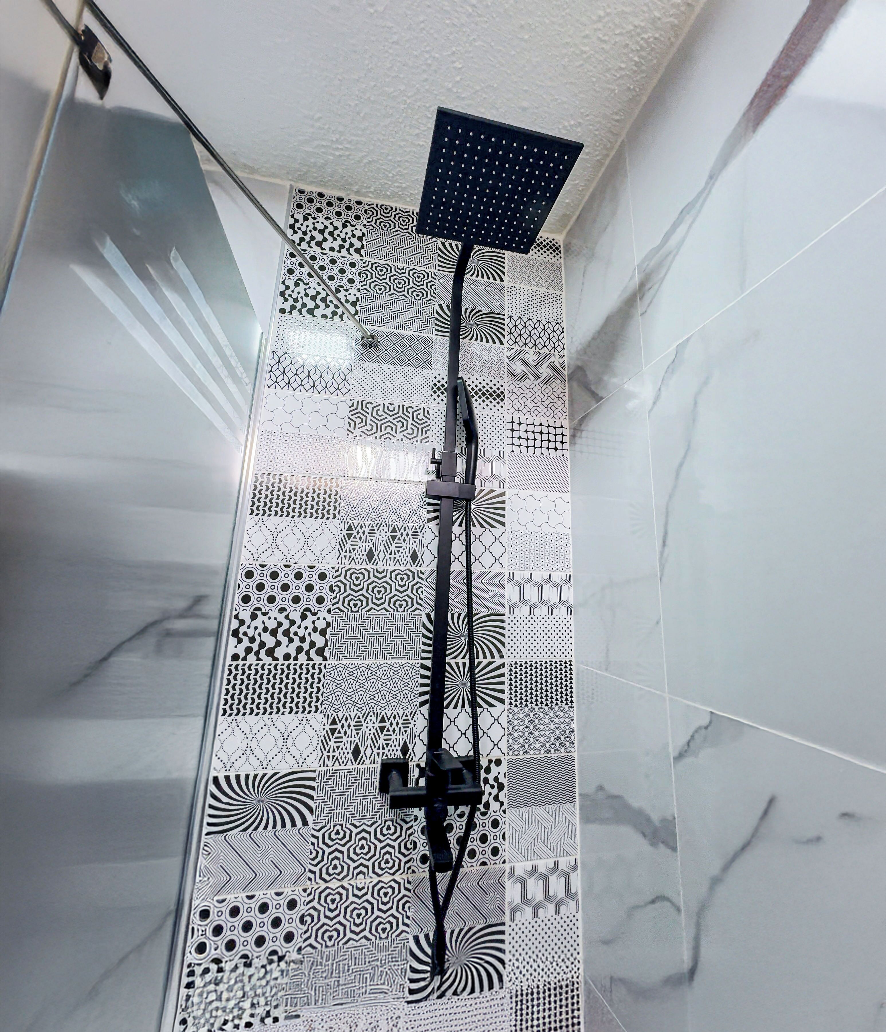 A shower with a black handheld showerhead and a square showerhead mounted on the wall.