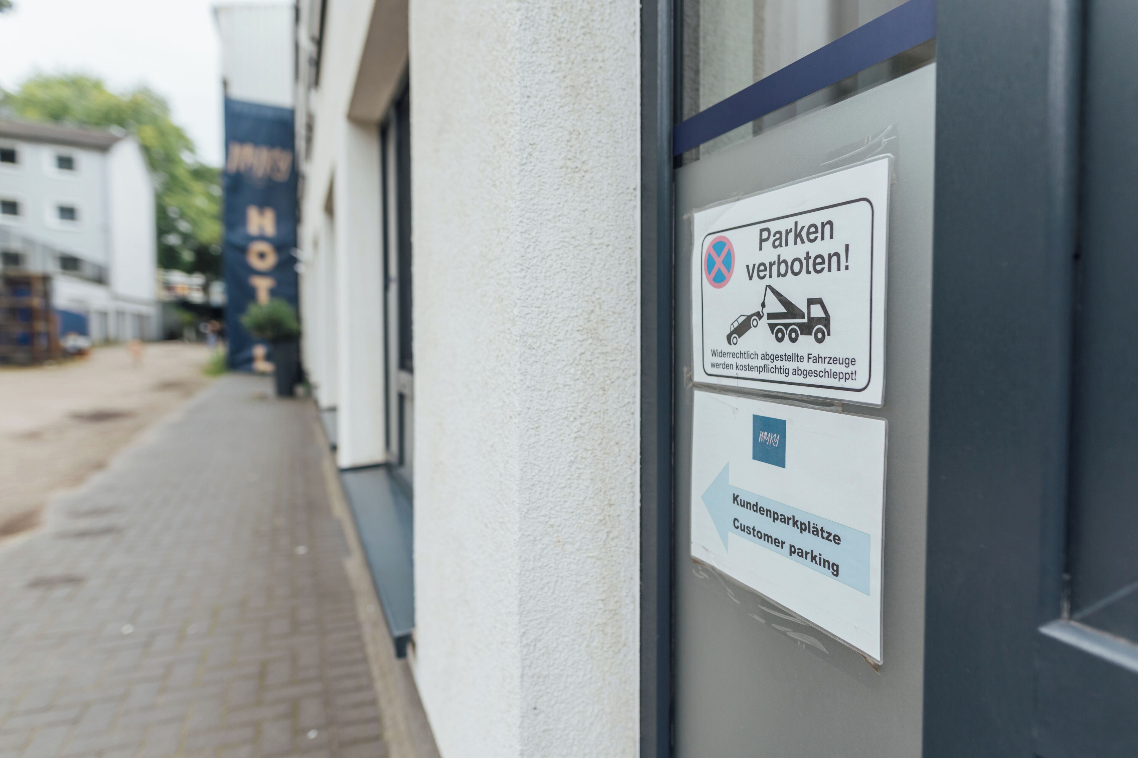Señal en un edificio que indica restricciones de estacionamiento y estacionamiento para clientes.