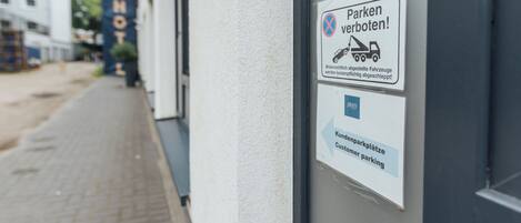 Señal en un edificio que indica restricciones de estacionamiento y estacionamiento para clientes.