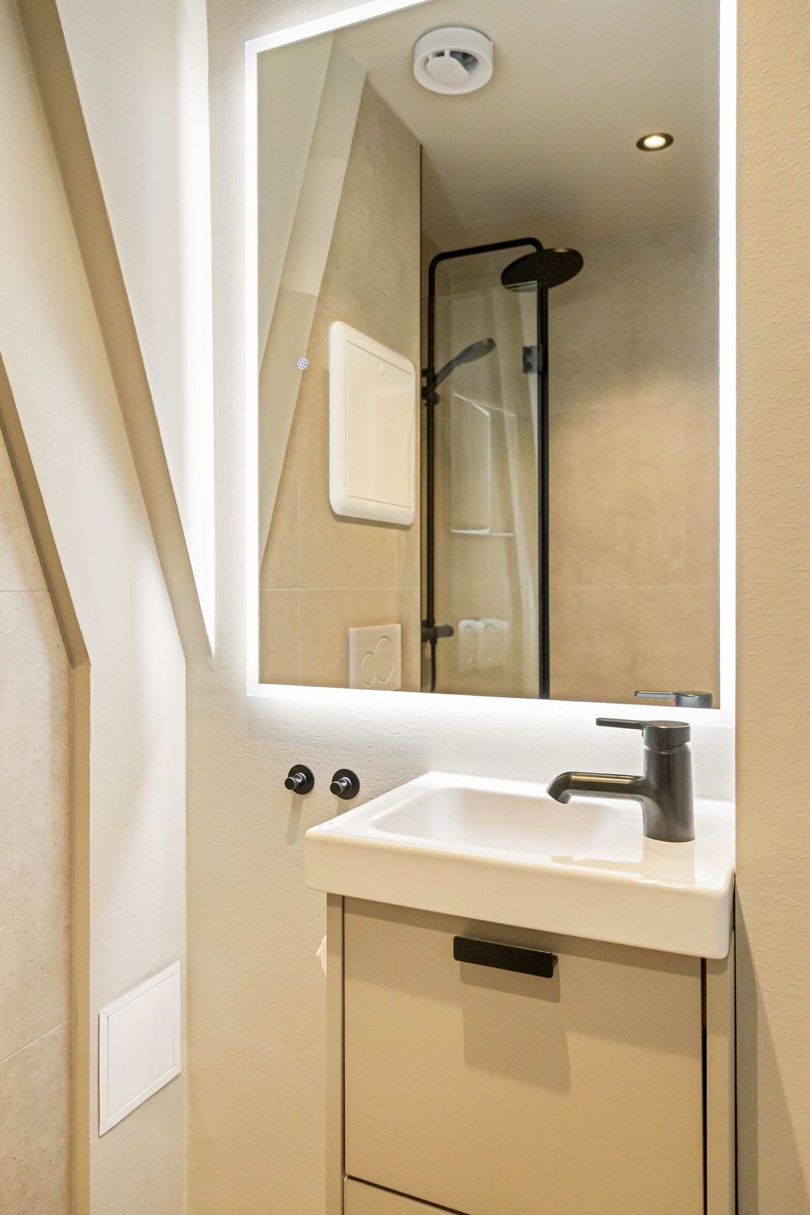 Ein Badezimmer mit Waschbecken, Spiegel und Dusche.