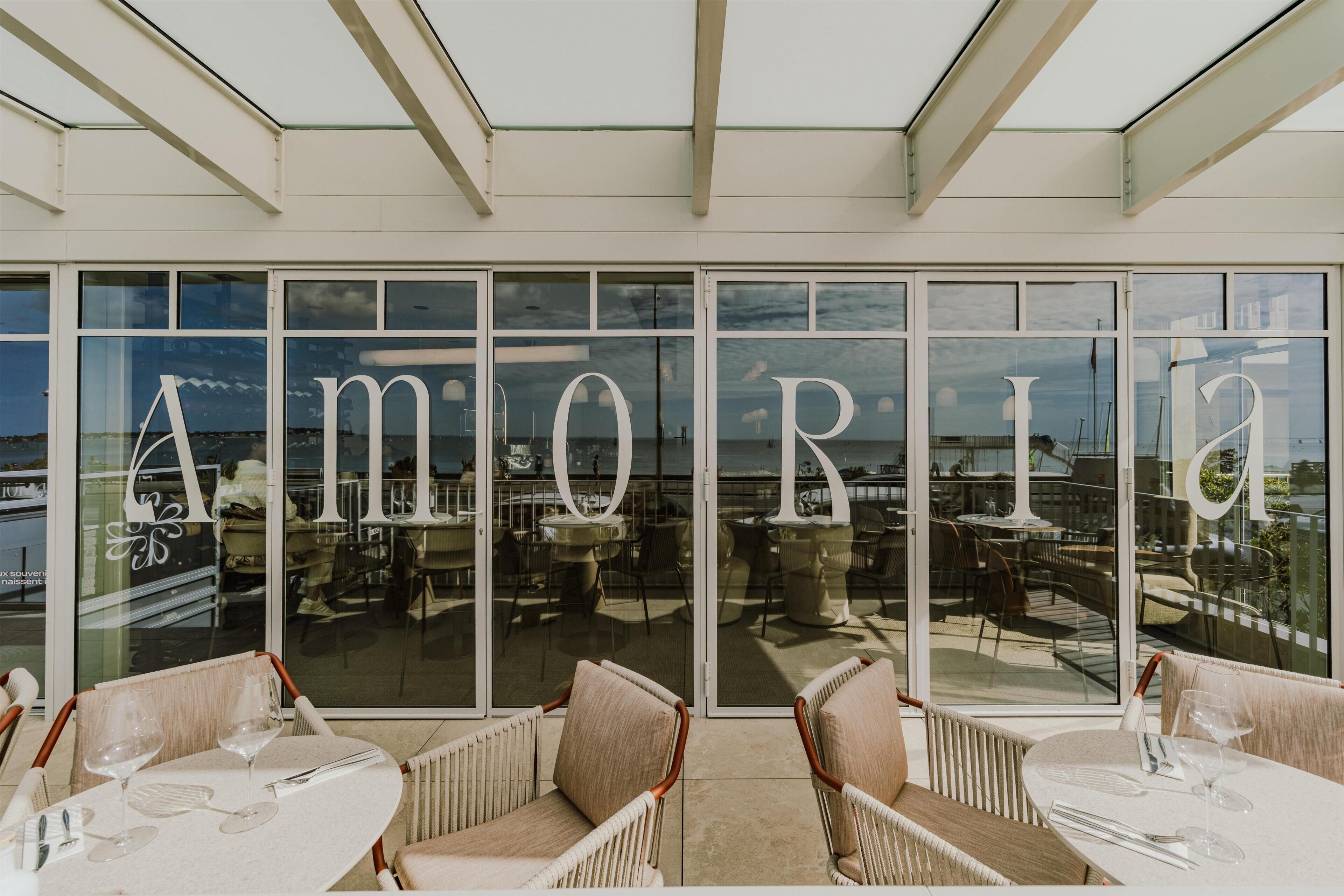 Un restaurante con amplios ventanales y terraza.