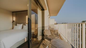 Un balcon avec un lit, une table et des chaises.