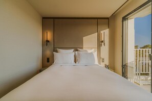 Une chambre d’hôtel avec un grand lit, une vue sur l’extérieur et un balcon.