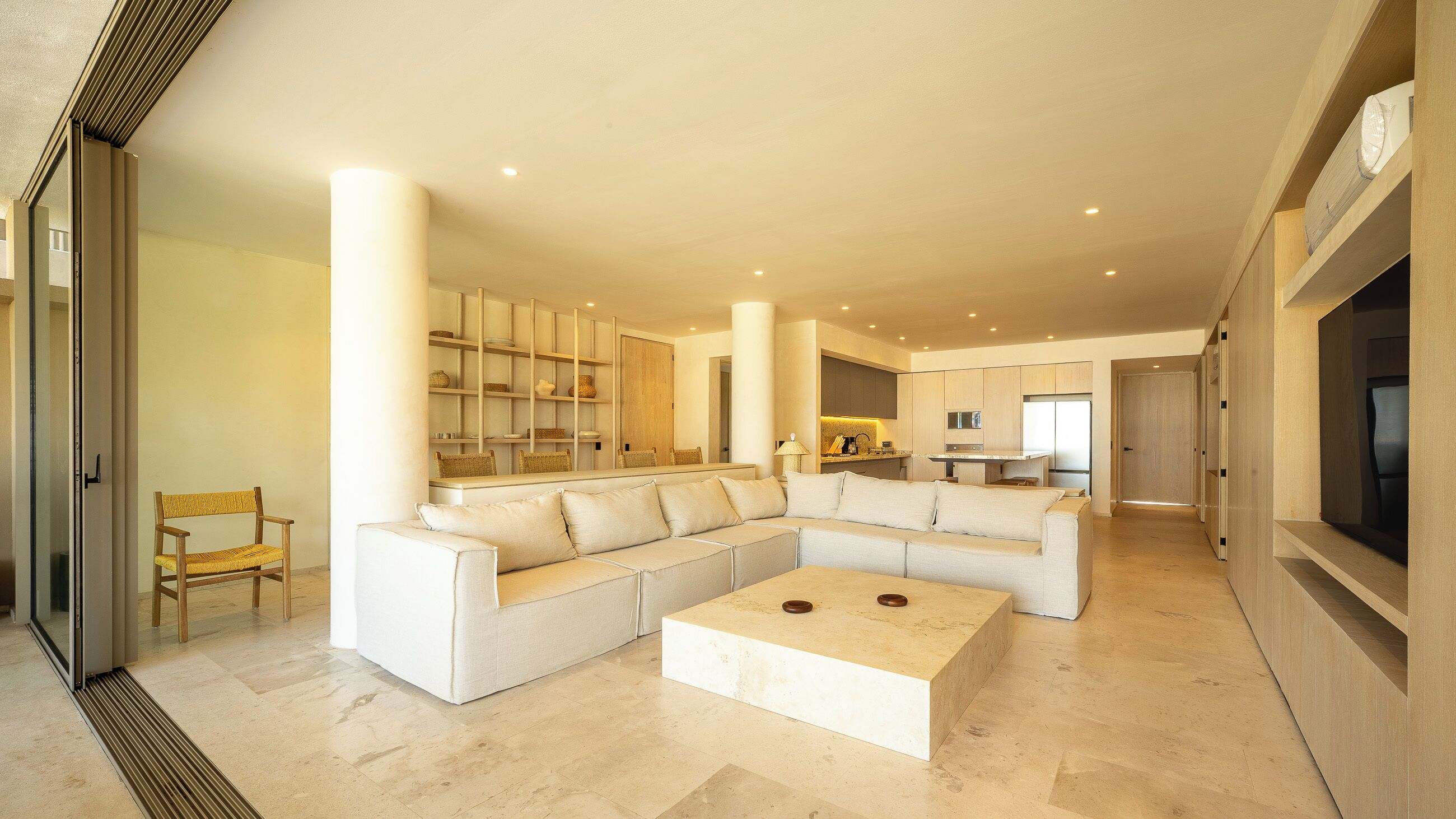 Amplia sala de estar con un sofá modular grande, una mesa de centro y una estantería empotrada.