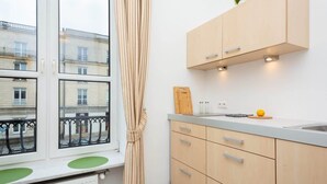 Una cocina pequeña con ventana, un radiador y una encimera con lavamanos.