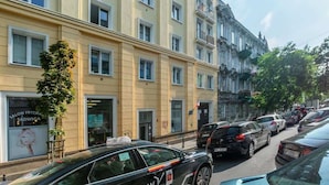 A multi-story building with a yellow facade, several windows, and a visible storefront with signage. - Cozy Studio in the Center | Close to Central Station (Warszawa)