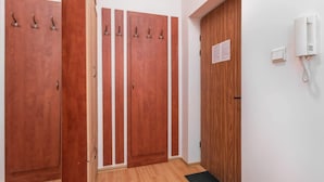 A hallway with wooden doors, a telephone, and a wall-mounted sign. - Cozy Studio in the Center | Close to Central Station (Warszawa)