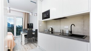 A modern kitchen with a built-in microwave, a kettle, and a sink.