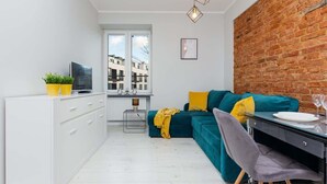 Ein modernes Wohnzimmer mit Küchenzeile, Esstisch und einer Couch.