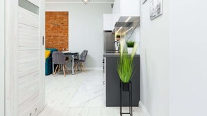 Eine moderne Küche mit schwarzem Arbeitsplatz, einer Hängelampe und einem Blumentopf.