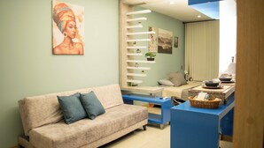 Ein modernes Wohnzimmer mit einer Couch, einem Couchtisch und einer Küchenzeile mit Arbeitsplatte und Schränken.