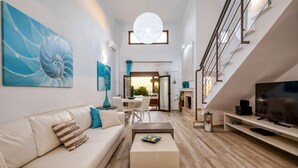 A modern living room with a sofa, coffee table, and TV stand. - Palmrise Luxury Villas - Maistros Villa (Kassandra)