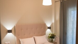 A neatly arranged bedroom with a large bed, bedside tables, and a hanging light fixture.