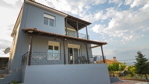 Een gebouw met twee verdiepingen, een balkon, een schotelantenne en een heldere lucht.