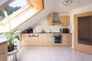 Eine moderne Küche mit Holzausstattung, integriertem Backofen und einem Oberlicht.