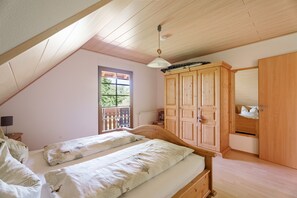 Ein Schlafzimmer mit zwei Betten, einem Holzschrank und einem Fenster mit Blick.