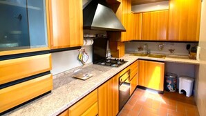 A kitchen with wooden cabinets, a gas stove, and a stainless steel range hood.