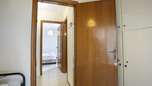 A hallway leading to a bedroom with a bed, a wardrobe, and a door. - Eria Home by Rentalspro - Trikorfo Halkidiki (Polygyros)