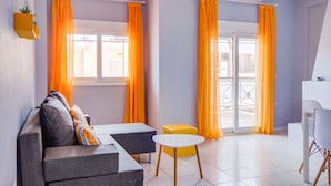 A modern living room with a sofa, a small table, and a balcony view. - Harmony Apartment 4 by Rentalspro (Kassandra)
