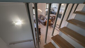 A staircase leading to a living area with a kitchen in the background. - Villa Elva by Rentalspro (Sithonia)