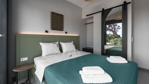 A modern bedroom with a large bed, green bedding, and a view of the outdoors. - Theeta Elia Villa - Metamorfosi Halkidiki (Sithonia)