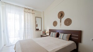 Un dormitorio con una cama grande, una mesita de noche, una lámpara y adornos en la pared.