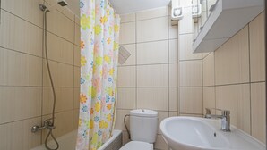 Un baño con ducha, inodoro y lavamanos.