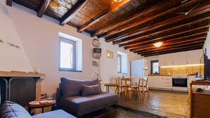 Una sala de estar acogedora con un sofá, una chimenea y un comedor con mesa y sillas.